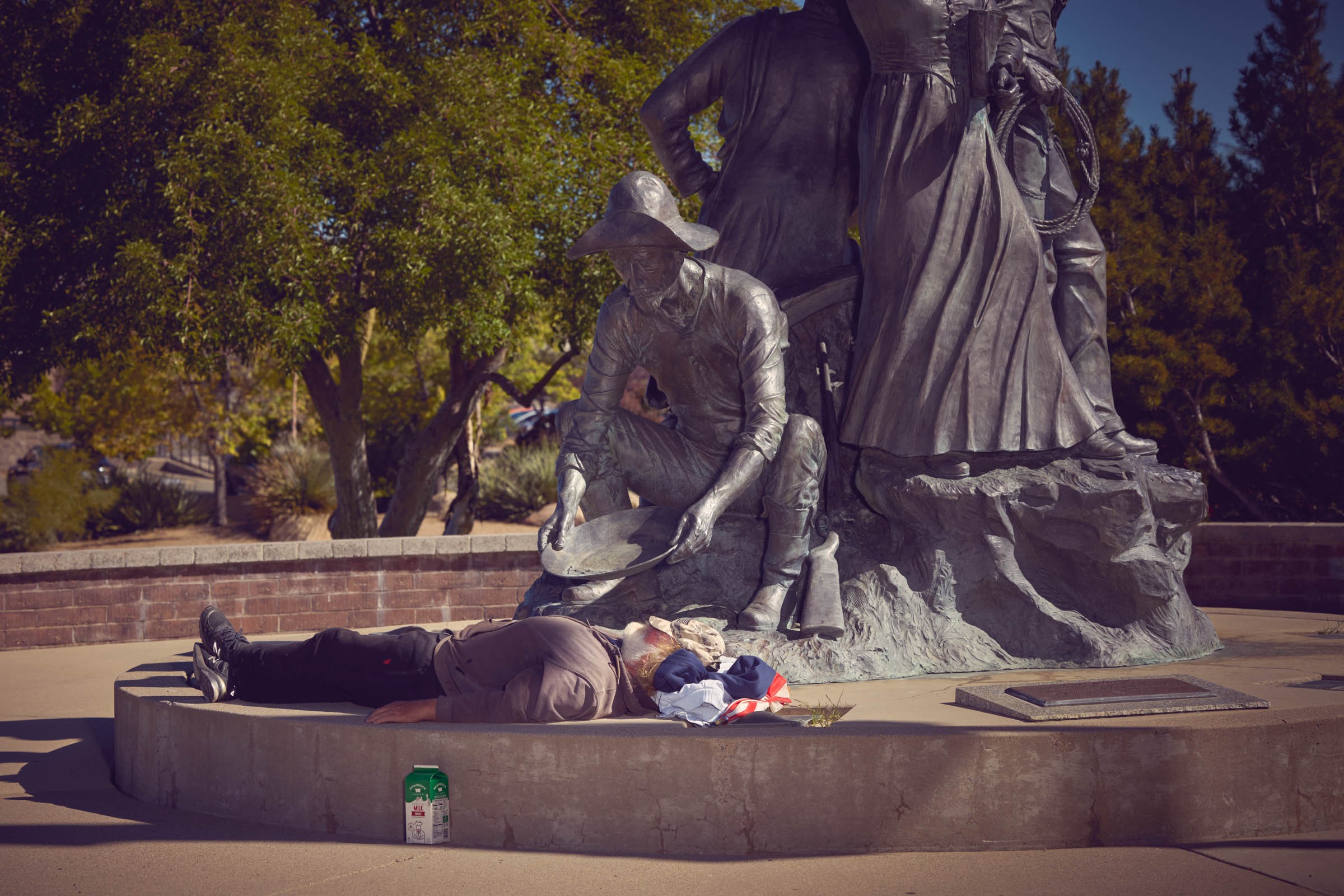 A man lays under a statue