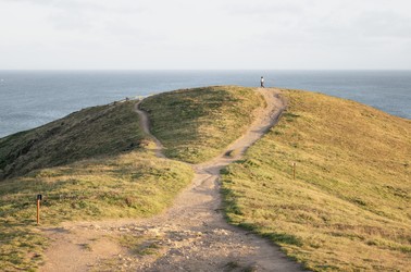 A single figure walking on a hilltop