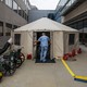 A doctor in front of a makeshift medical tent.