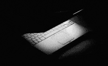 Illustration of a half-closed laptop with a flickering screen light