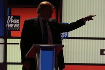 Trump points in front of a Fox News sign.