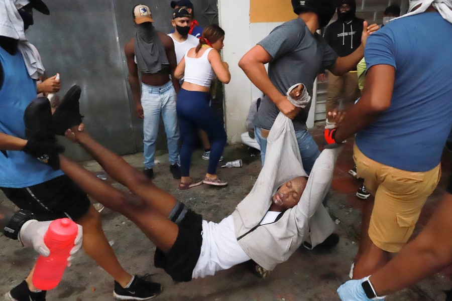 People carry a wounded man.