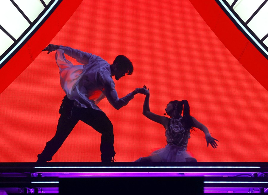 A singer and a dancer perform on a stage.