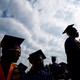 People in graduation caps sit together.