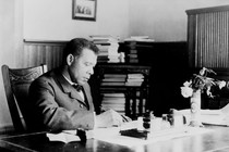 Booker T. Washington sits writing at his desk