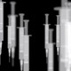 A handful of vaccine syringes photographed in black and white appear to be floating
