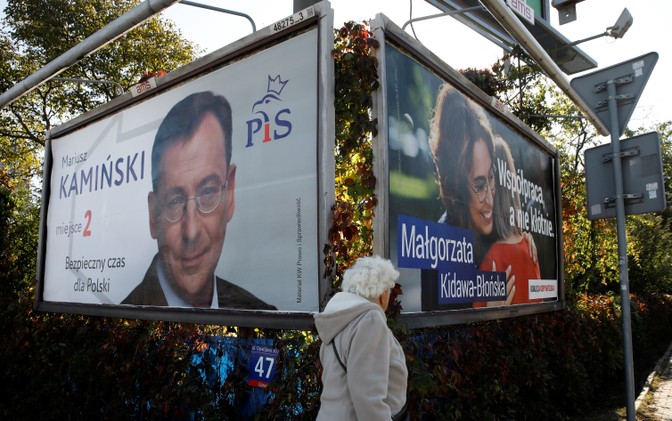 A woman walks in front of election posters in Warsaw.