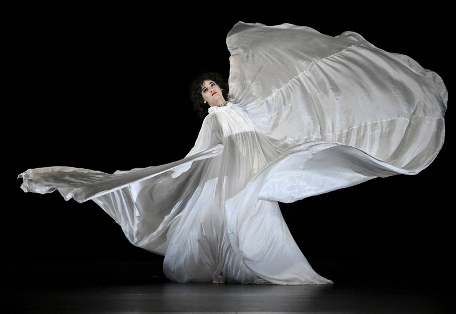 A dancer spins, wearing a flowing white costume that swirls around them.