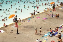 Photograph of people swimming, wading, and relaxing at a public pool