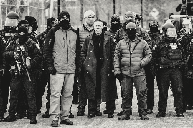 a photo of Greg Bovino in Minneapolis wearing a long "great coat" reminiscent of German military coats in the 1930s, surrounded by masked federal agents