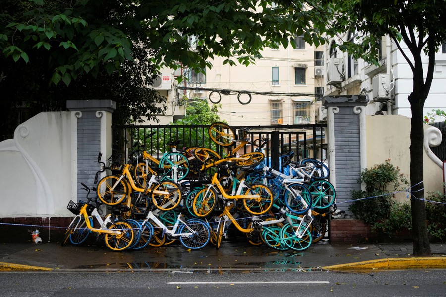 A gate is blocked by a pile of bicycles.
