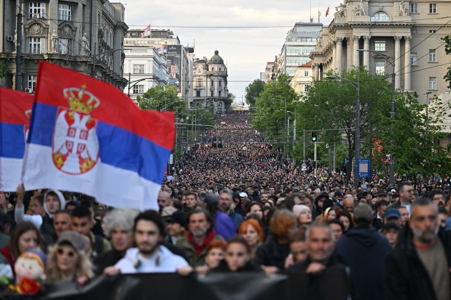 A city street is filled with thousands of protesters marching.