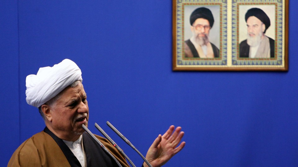Former President Ali Akbar Hashemi Rafsanjani speaks under the pictures of Iranian late spritual leader Ayatollah Khomeini, right, and supreme leader, Ayatollah Ali Khamenei.