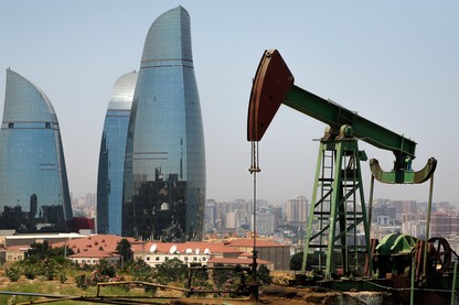 an oil pump works a nearby hill in Baku, Azerbaijan