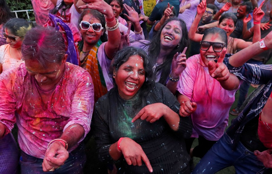 A crowd of celebrating people, covered in many colors