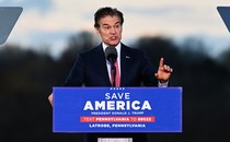 Dr. Mehmet Oz speaks at a lectern that reads "Save America"