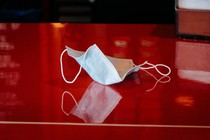 A discarded mask lies on a shiny red countertop