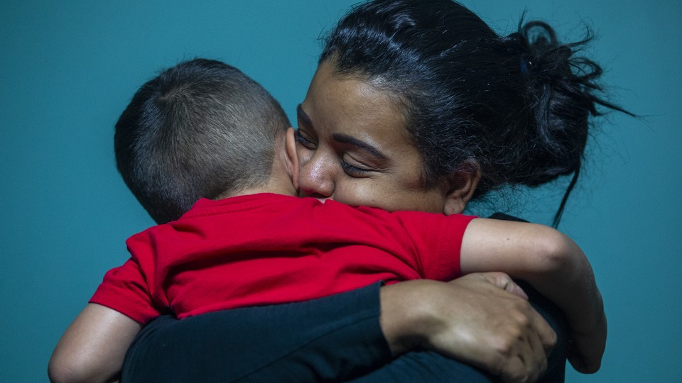 A woman hugs a small boy