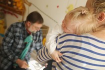 A woman holds a small child.