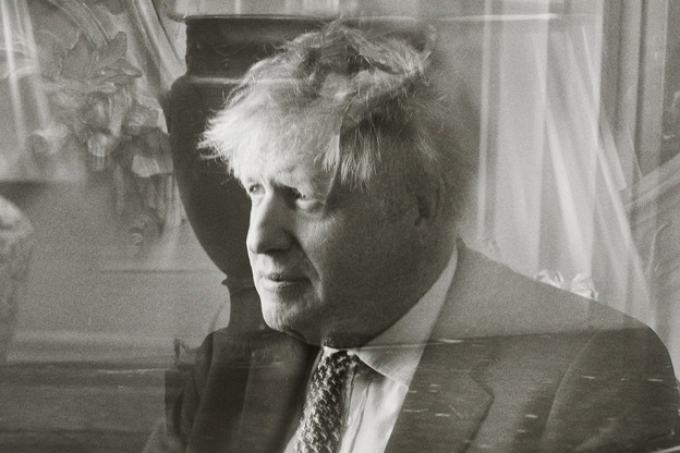 Photo: Prime Minister Boris Johnson seated, with a superimposed reflection through glass, 10 Downing Street, May 2021