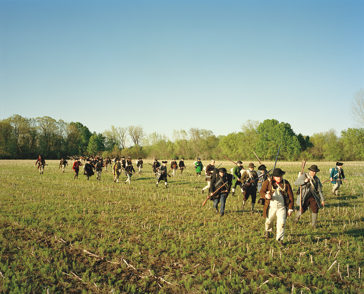 photo of reenactors as American soldiers hiking towards Fort Ticonderoga across an open field