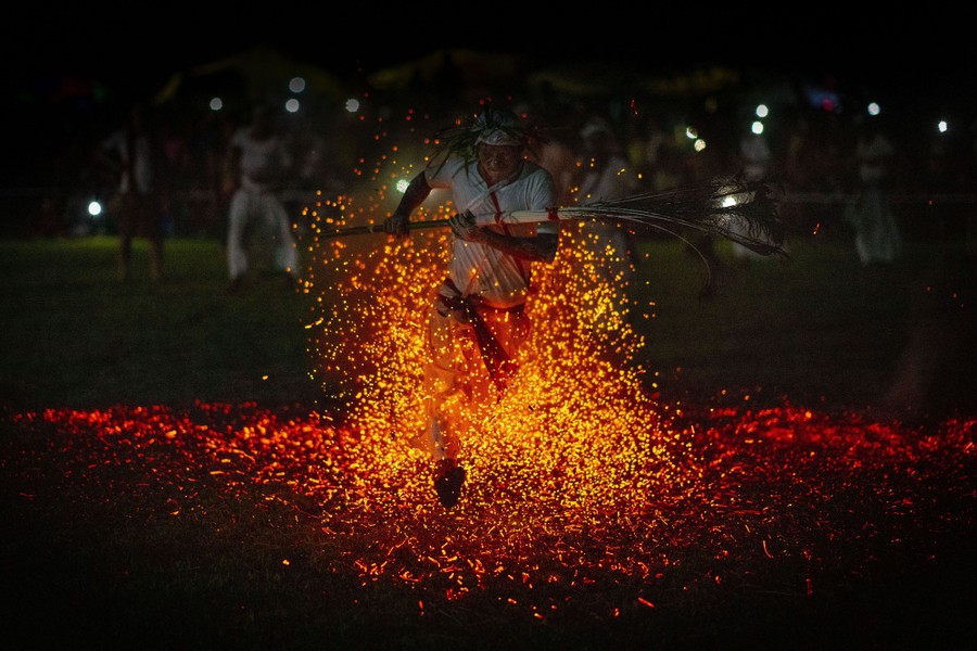 A person runs through a pile of burning embers.