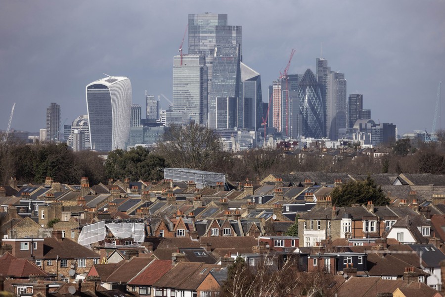Towers in the City of London loom in the distance beyond rows of housing.