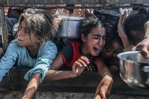 Displaced Palestinians including women and children living in tents receive food distributed by aid organizations in al Mawasi district of Khan Yunis, Gaza on May 30, 2025.