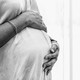 A pregnant woman holds her belly.