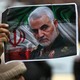 A protester holds up a picture of late General Qassem Soleimani.