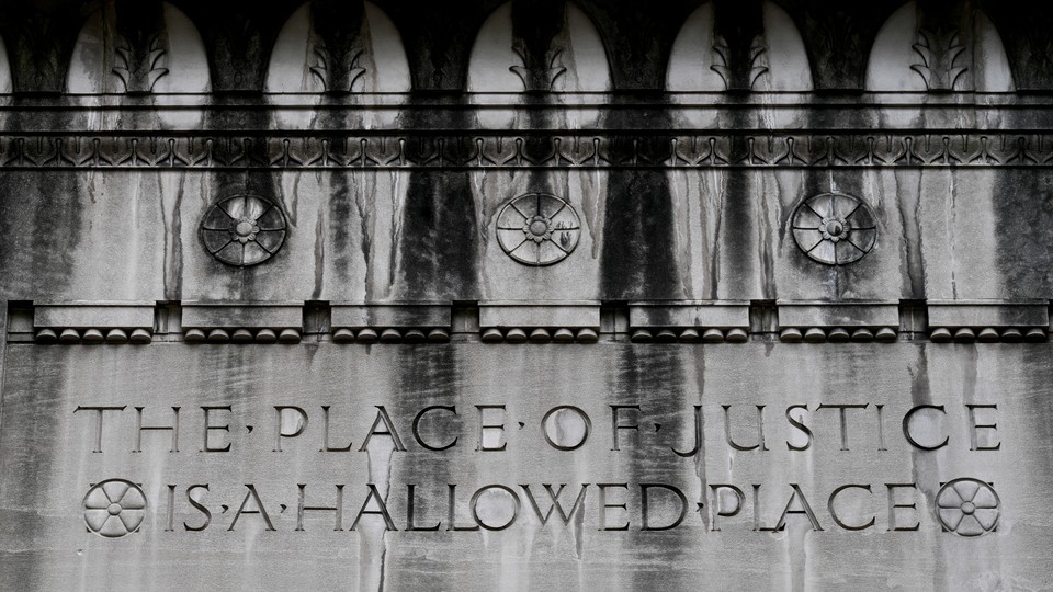 Etchings on the wall on the outside of the Department of Justice that read, "The place of justice is a hallowed place"