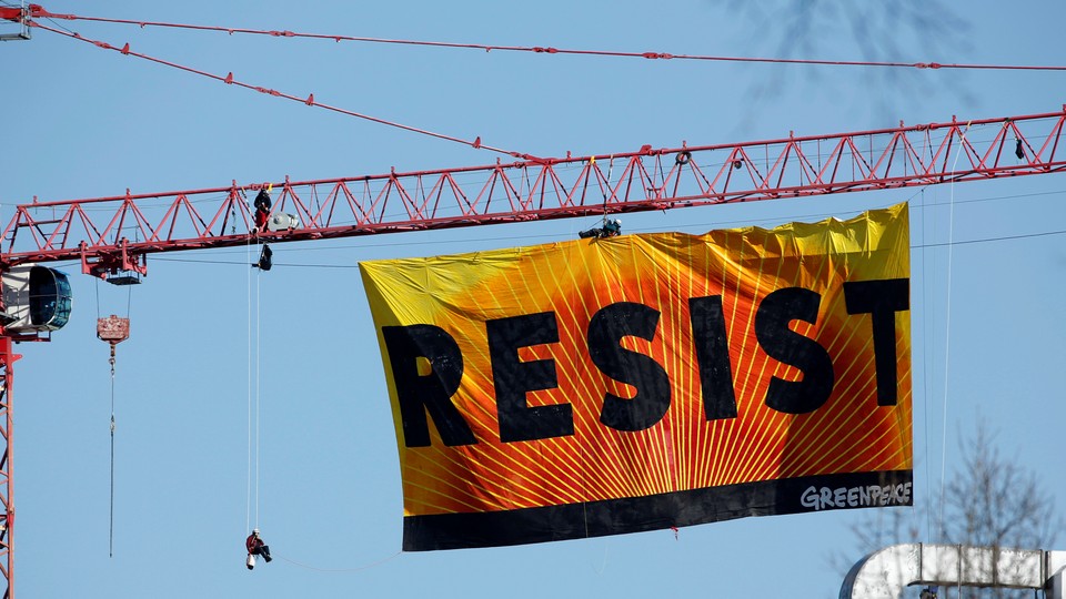 A banner reading “RESIST” hangs off a crane near the White House in Washington, D.C.