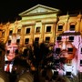 photo: projections of Trump and Salman's portraits on the side of a building at night