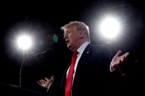 President Donald Trump speaking into a microphone