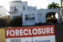 A foreclosure sale sign sits in front of a house in Miami Beach.