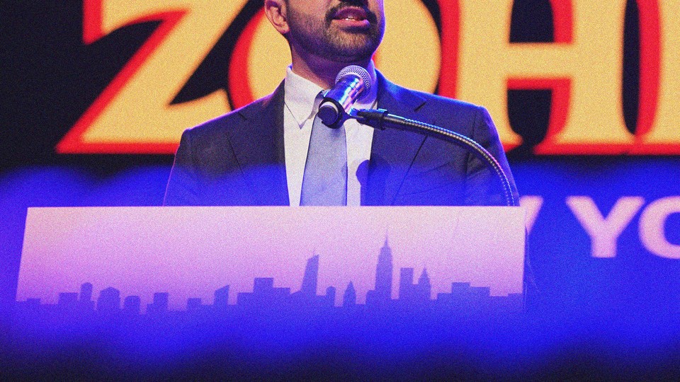 Photograph of Zohran Mamdani speaking at a podium during a campaign event with the top of his head cropped out of the frame