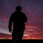 Silhouette of soldier over a sunset sky
