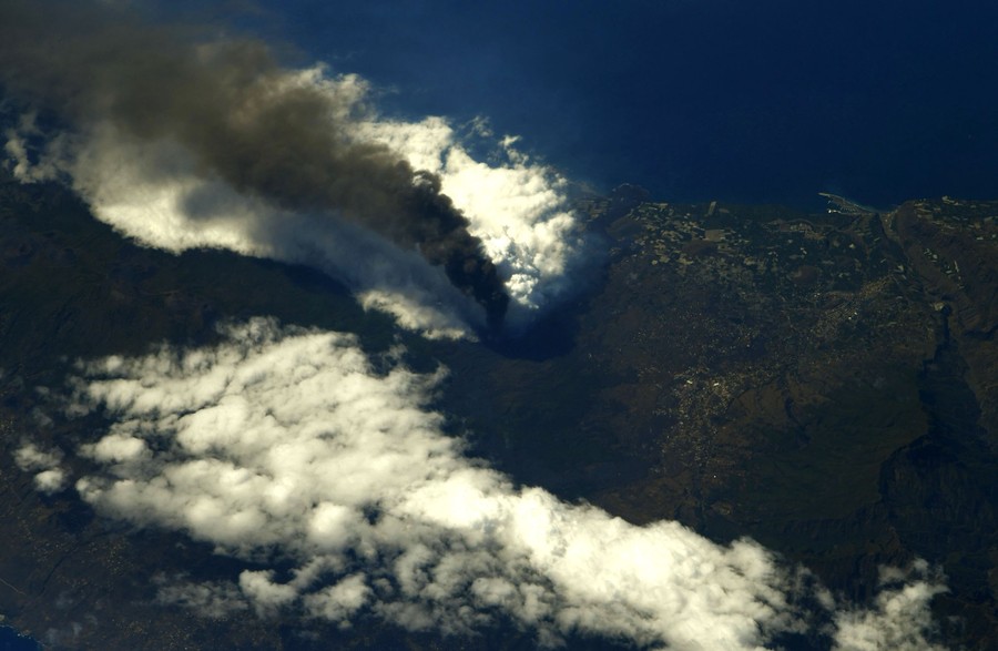 A plume of ash rises from a volcano.