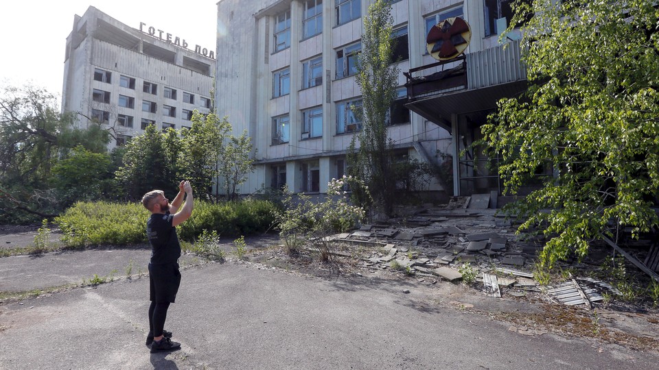 A man takes a photo of ruins in Pripyat, Ukraine.
