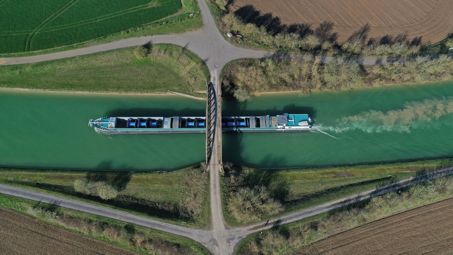 An aerial view of a river barge sailing along a canal