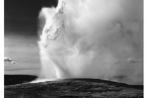 A black and white photograph of Old Faithful geyser erupting in Yellowstone National Park, Wyoming, between 1941 and 1942