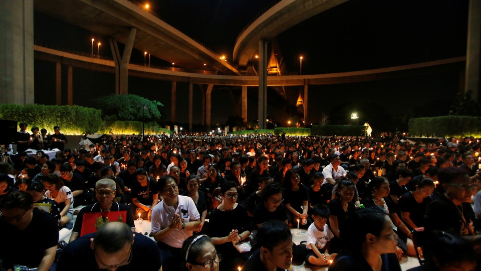People pay their respect to the late King Bhumibol Adulyadej during a candlelight vigil at Lat Pho Park in Song Khanong, Thailand October 19, 2016.