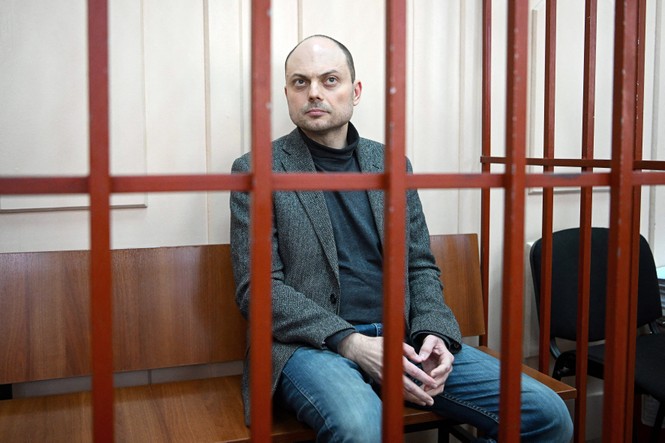 Russian opposition activist Vladimir Kara-Murza sits on a bench inside a defendants' cage during a hearing at the Basmanny court in Moscow on October 10, 2022. 