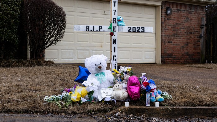 A memorial to Tyre Nichols with stuffed animals, flowers, and a cross