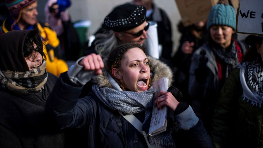 A protester shouts slogans among other protesters.
