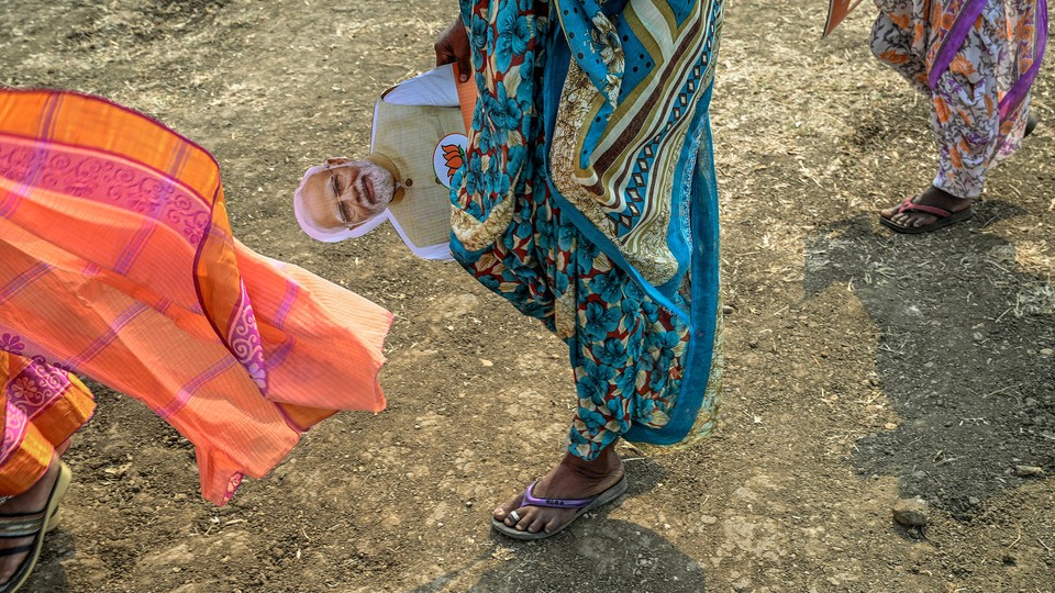 a supporter of Prime Minister Narendra Modi with a cutout of his face at a campaign rally in Chandrapur, India, on April 8, 2024.