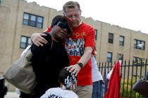 Michael Pfleger, a Chicago priest and voice in the anti-violence movement in the city, comforts the family of a shooting victim earlier this year.