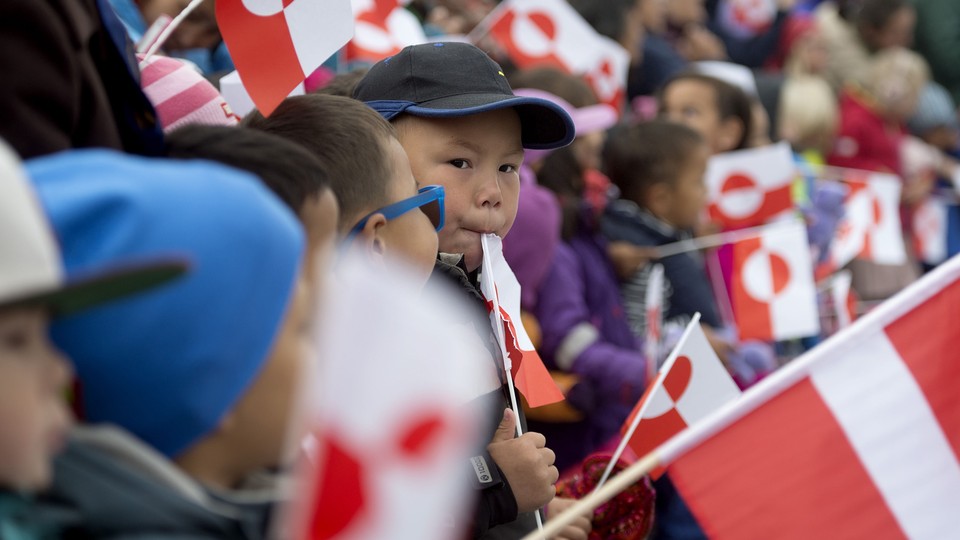 Children holding Greenland's national flag