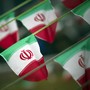 Iran's national flags are seen fluttering on a string in a square.