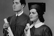 A man and a woman hold college diplomas
